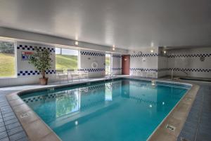a large swimming pool with blue water in a building at Baymont by Wyndham Golden/Red Rocks in Lakewood