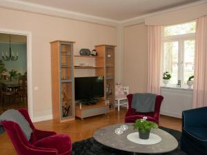 uma sala de estar com cadeiras vermelhas e uma televisão em Ekeby i Bro em Bro
