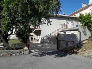 Un edificio con una puerta y un árbol delante. en Apartment Damir, en Senj