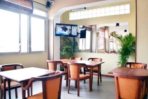 a dining room with tables and chairs and a tv at A l'hotel in Antananarivo