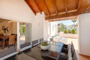 a living room with a glass table and chairs at Hanami Alcazaba Beach Penthouse in Estepona