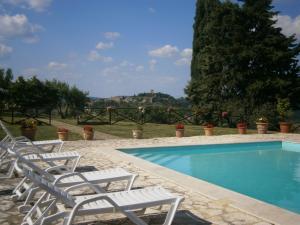 a swimming pool with lounge chairs next to it at Agriturismo Collosodo in Monticchiello
