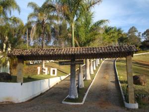 uma longa estrada com palmeiras num parque em Pousada das Palmeiras em Camanducaia