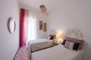 - une chambre avec 2 lits et une fenêtre dans l'établissement Villa Fontanelle, à Villanova di Ostuni