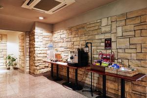 a lobby with a stone wall and a coffee shop at Nasushiobara Station Hotel in Nasushiobara