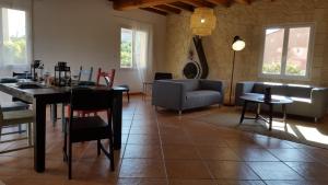 uma sala de estar com uma mesa e cadeiras e um sofá em Maison Les Pins em Aigues-Mortes