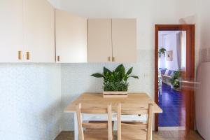 une cuisine avec une table en bois et une plante en pot. dans l'établissement Villa Fontanelle, à Villanova di Ostuni