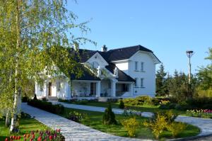 una casa blanca con un jardín delante de ella en Zielone Zacisze en Murzynowo Kościelne