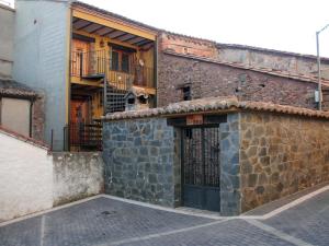 un ancien bâtiment en pierre avec une porte dans une rue dans l'établissement Tia Rulla 1, à Pina de Montolgrao
