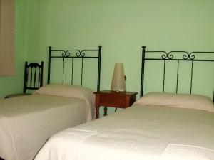 two beds in a room with green walls at Tia Rulla 1 in Pina de Montolgrao