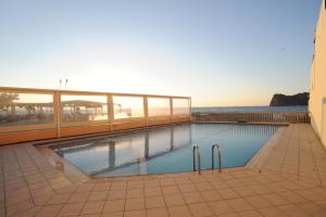 a swimming pool on a building with the ocean in the background at Georgina in Agia Marina Nea Kydonias