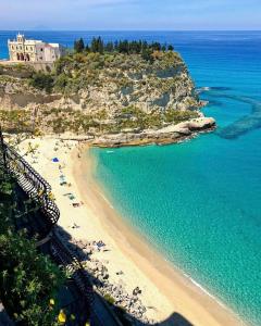 a beach with a group of people and the ocean at Residenza Dama in Santa Domenica