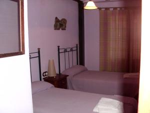 1 dormitorio con 2 camas y lámpara en Tia Rulla 2, en Pina de Montolgrao