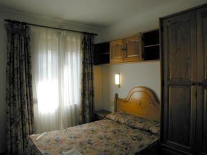 1 dormitorio con cama y ventana en Apartamentos Gabarre, en Broto