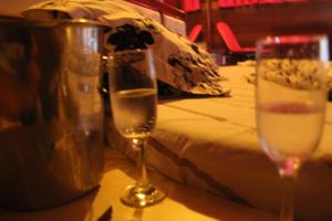 Motel Paradise (Adults only) في ساو جوزيه دوس كامبوس: طاولة مع كأسين على طاولة مع سرير