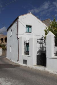 a white building with a black door on a street at B&B Charme Sa Pardina in Orroli
