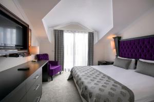 a bedroom with a large bed with a purple headboard at Blueberry Boutique Hotel in Fethiye +69 photos