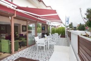 a patio with white chairs and tables on a building at Blueberry Boutique Hotel in Fethiye