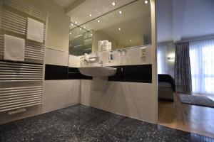 a bathroom with a sink and a mirror at Hotel Stadt Hamburg in Heiligenhafen +55 photos
