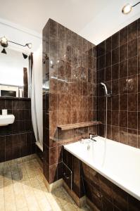 a bathroom with a tub and a sink and a shower at A Place Like Home Apartamenty Witosa in Gdańsk