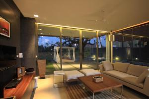 a living room with a couch and a large window at Luxury Goa Villa in Candolim