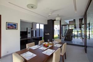 a dining room with a wooden table and chairs at Luxury Goa Villa in Candolim