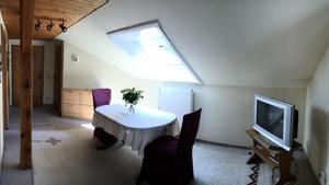 a living room with a white table and a tv at Ferienwohnungen Weigert Homes eG in Nittendorf