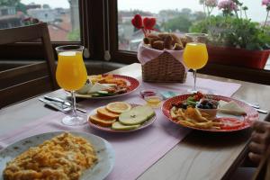 a table with plates of food and two glasses of orange juice at Emine Sultan Hotel in Istanbul