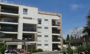 a white apartment building with cars parked in front of it at Via Calanca in Marseille