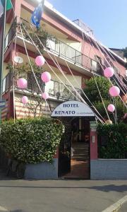 a hotel with pink umbrellas hanging from a building at Hotel Renato in Sesto San Giovanni