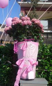 a pink vase filled with pink flowers and balloons at Hotel Renato in Sesto San Giovanni