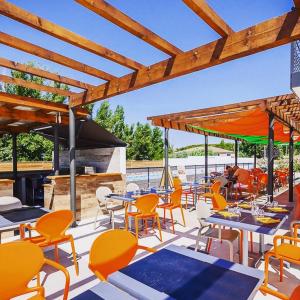 a restaurant with tables and chairs and a grill at Adonis Aix en Provence in Aix-en-Provence