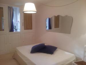 オストゥーニにあるTrullo Casa Loanのベッドルーム(白いベッド1台、青い枕付)