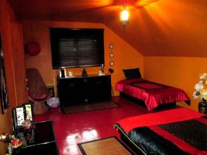sypialnia z 2 łóżkami i czerwonym dywanem w obiekcie Gite Agricole Les Lilas w mieście Saint Wenceslas