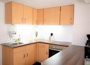 a kitchen with wooden cabinets and a sink at Work & Stay in Zuelpich in Zülpich