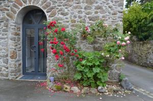a stone building with flowers in front of a door at Maison Coetquen in Saint Malo