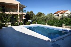 a swimming pool in front of a house at Apartments Marija in Bibinje