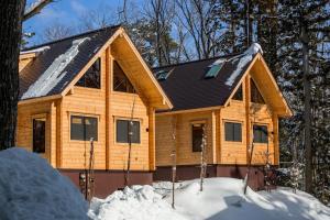 a log cabin in the woods in the snow at Wadano Woods by Hakuba Hotel Group in Hakuba