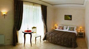 1 dormitorio con cama, mesa y ventana en Gomer Hotel (Adults only), en Balaklava