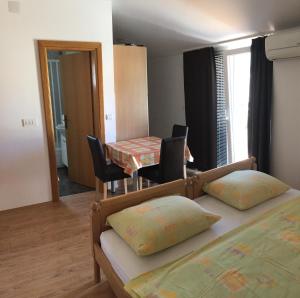 una camera con due letti e un tavolo con sedie di Apartmani MM a Tkon (Tuconio)