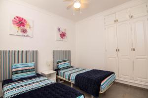 une chambre avec deux lits et un ventilateur de plafond dans l'établissement Villa Sontrobat, à Puerto del Carmen