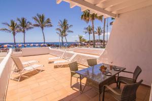 a patio with a table and chairs and the beach at Villa Sontrobat in Puerto del Carmen
