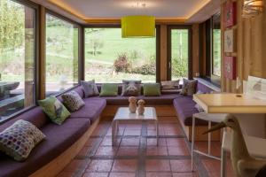 a living room with a purple couch and windows at Hostellerie Les Bagenelles in Sainte-Marie-aux-Mines