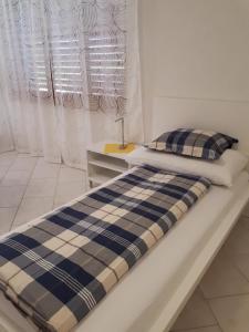 a bed with a blue and white plaid blanket at good bed Lotzwil in Lotzwil