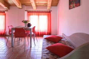 CarassaiにあるAgriturismo Annarellaのリビングルーム(テーブル、赤い枕付)