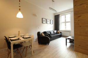 a living room with a table and a couch at Długa Apartments Old Town in Gdańsk