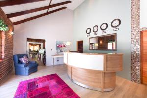 a lobby with a reception desk and a chair at Swallows Nest Country Cottages in Stormsrivier