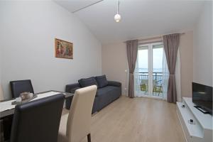 een woonkamer met een bank en een tafel met een bureau bij Sea View Apartment Gin Brela in Brela