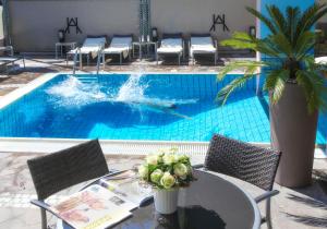 a pool with a table and a dolphin in the water at Hotel Ambassador in Riccione