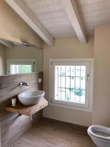 baño con lavabo, ventana y aseo en Casa Bardalla, en Ponti Sul Mincio